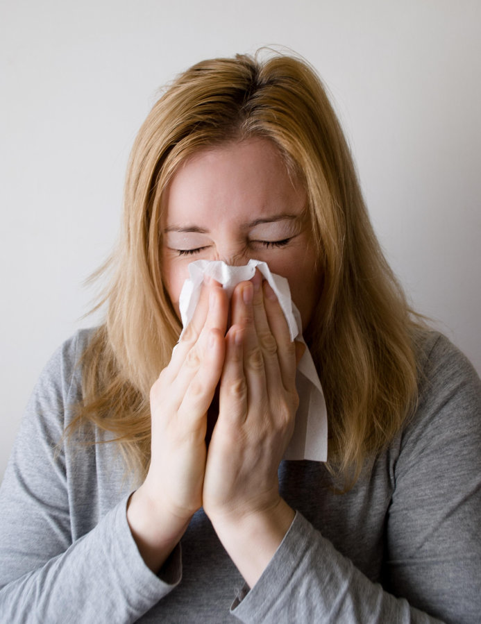 lady with influenza blowing nose